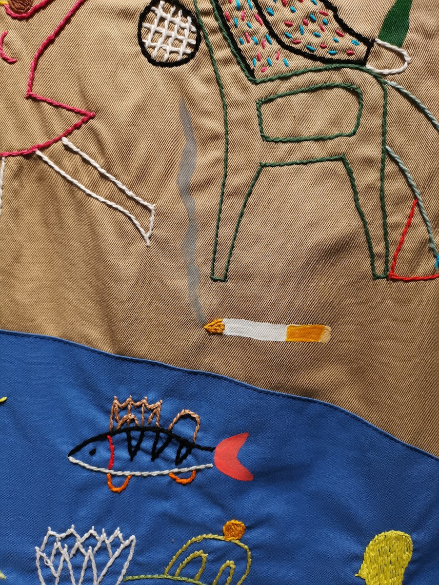 Finished sew-out: red and yellow logo embroidered on blue textile
