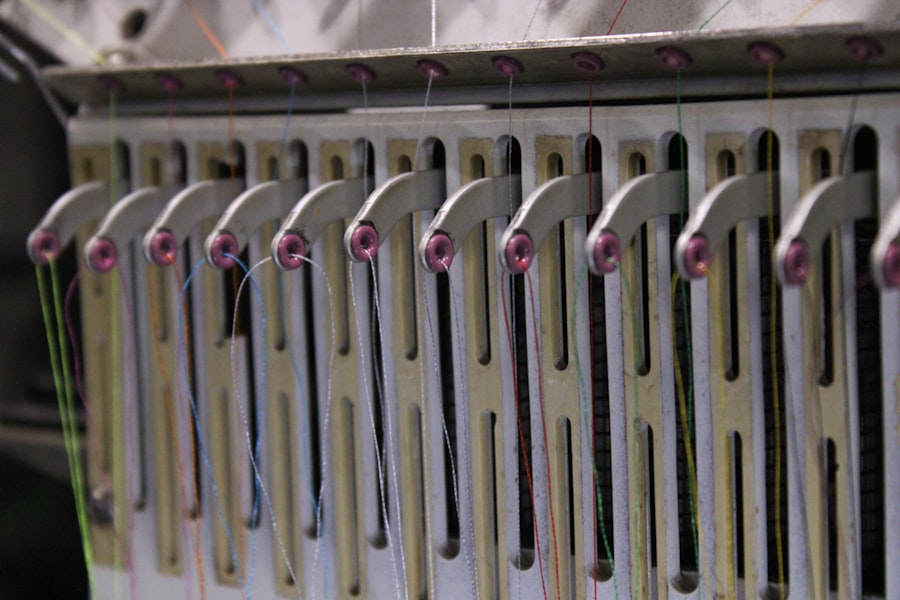 Close-up of an embroidery machine's thread guides with colored threads running through