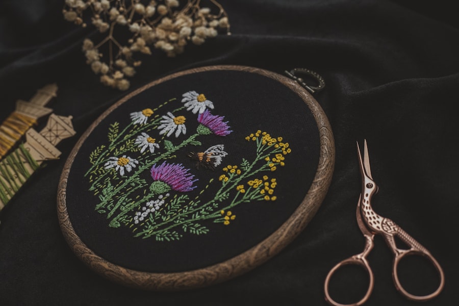 Wildflower embroidery in a hoop on black cloth beside stork scissors